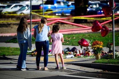 three people stand at a memorial
