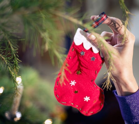 Someone decorates a Christmas tree with a handmade decoration
