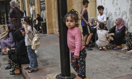 Little girl hugs a lamp-post in Beirut street scene, 12 October 2024.