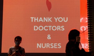 Pedestrians pass an electronic sign with a message of thanks to doctors and nurses in Hong Kong on May 13, 2020.