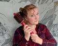 Lise Smith holds a round hot brush to her hair, smiling and glancing sideways