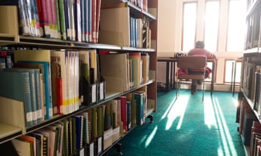 Rear view of a student sitting at a desk studying in the library, Llanbadarn campus, at Aberystwyth University, in 2013