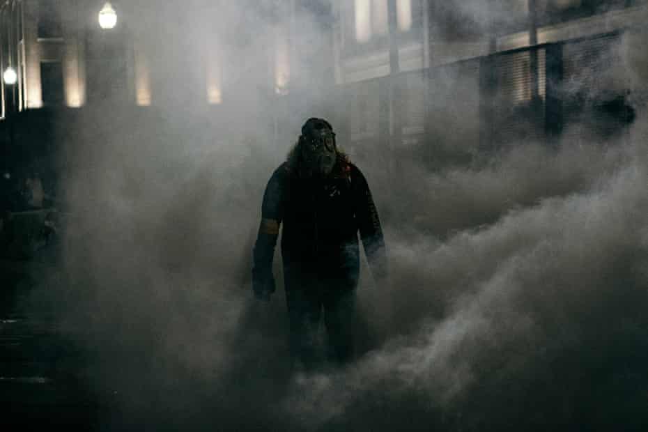 A demonstrator stands in a cloud of tear gas on Tuesday in Kenosha, Wisconsin.