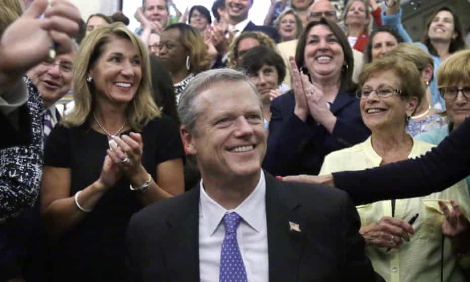 Governor Charlie Baker of Massachusetts smiles with Lieutenant Governor Karen Polito, left, and Dorothy Simonelli, right, and others after he signed an equal pay bill into law on Monday in Boston.
