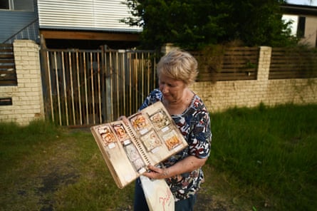 Margaret Kloostra, a former resident of Enid Street, holds a destroyed family album outside a condemned home