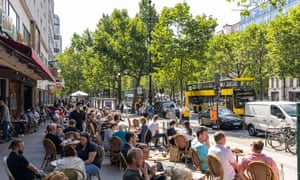 People sit outside a restaurant near the popular shopping street Kurfürstendamm in Berlin.
