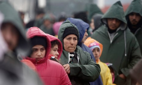 Refugees and migrants wait to cross the Greek-Macedonian border