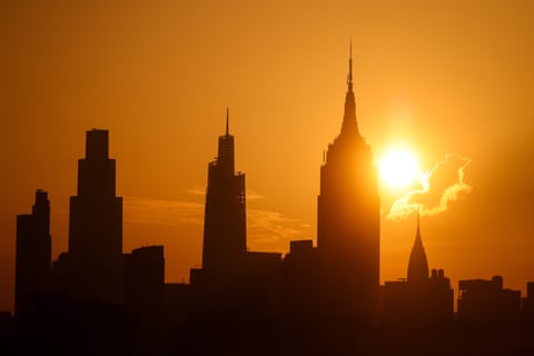 The sun behind silhouetted buildings in Manhattan.