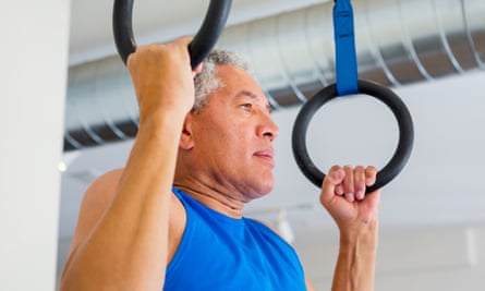 Man using pull-up rings in gymnasium
