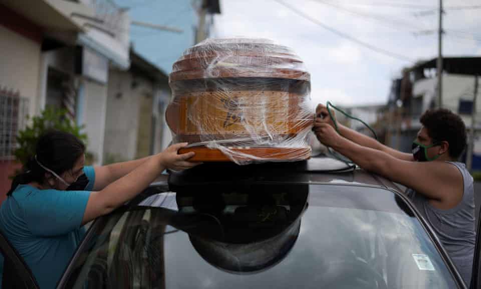 A couple tie an empty coffin to their car to collect the body of a relative in Guayaquil