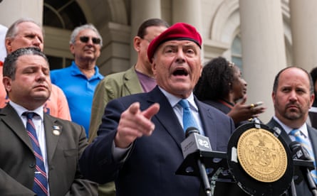 a man in a suit and a red beret speaks into a microphone