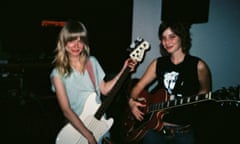 Two young women standing with guitars.