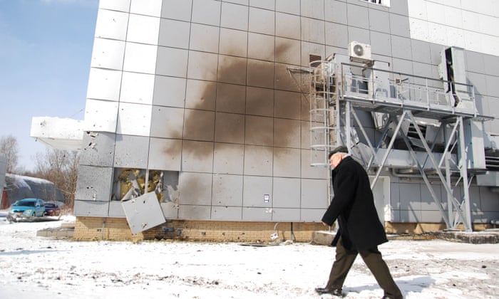 A man walks past a damaged part of the National Science Center in Kharkiv.