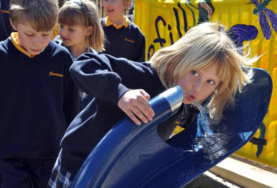 Schoolkinderen staan ​​in de rij om te drinken uit een nieuwe openbare drinkfontein op de eerste dag van een verbod op flessenwater in de gemeenschap van Bundanoon in de Zuidelijke Hooglanden op 26 september 2009. De 2,000 inwoners tellende stad haalde al het flessenwater uit de schappen en verving ze door hervulbare flessen in wat wordt beschouwd als een eerste verbod ter wereld. AFP PHOTO/Penny SPANKIE (Fotocredit zou Penny SPANKIE/AFP/Getty Images moeten zijn)