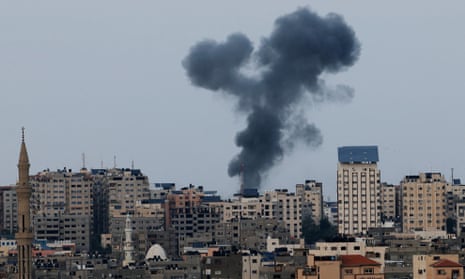 A plume of black smoke rises above Gaza City's skyline during an Israeli air strike.