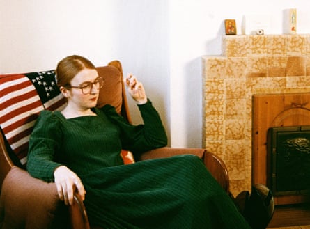 Jennifer Walton sitting in an armchair by a retro fireplace