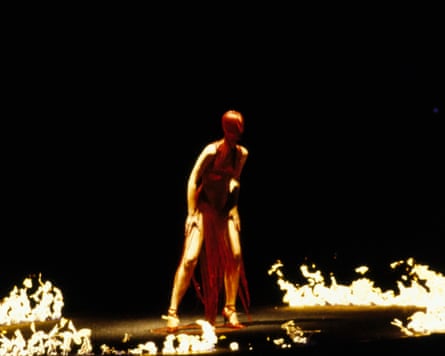 A model on the catwalk surrounded by flames.