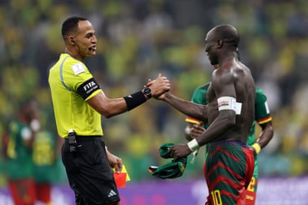 Referee Ismail Elfath (left) congratulates Vincent Aboubakar of Cameroon scoring Cameroon’s first goal against Brazil before showing him a second yellow and then a red card for taking off his jersey during the celebrations.