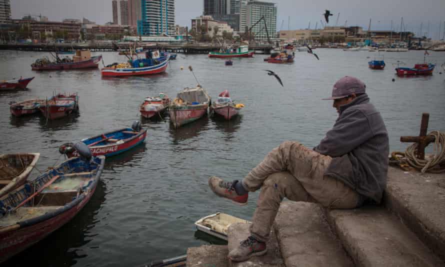 A dock worker waits for fishermen to return to Antofagasta harbour.