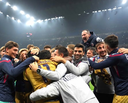 Bologna’s Samuel Mbangula is surrounded by teammates and coaches after scoring his third goal against Milan.