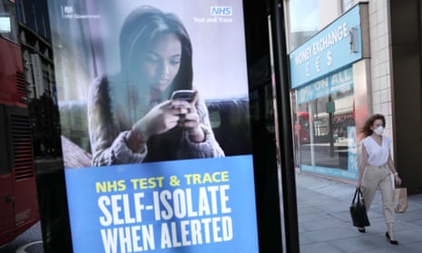 A woman walks past an advert for the test-and-trace system in London