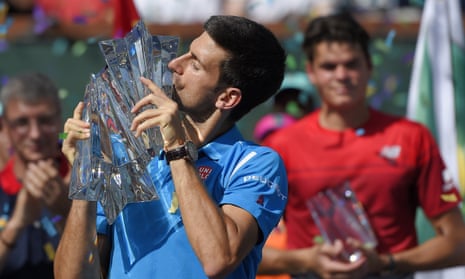 Novak Djokovic celebrates winning the BNP Paribas Open title in Indian Wells as runner-up Milos Raonic watches on