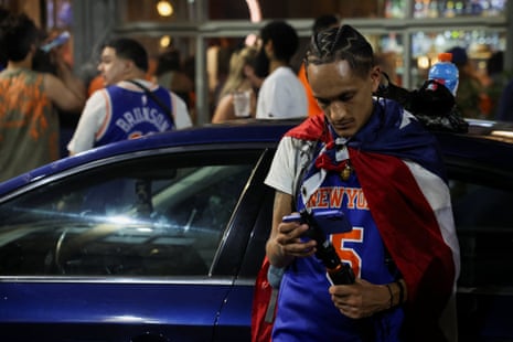 A Knicks fan in New York watches Game 5 on his phone.
