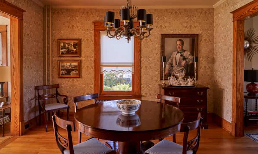 Uma sala de jantar com cadeiras de reprodução Duncan Fyfe da década de 1940 e um retrato de 1942 de um cavalheiro do sul das Galerias Stewart em Palm Springs.