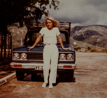 The birth mother of writer David Batty, dressed in white top and trousers, leaning against the bonnet of a car