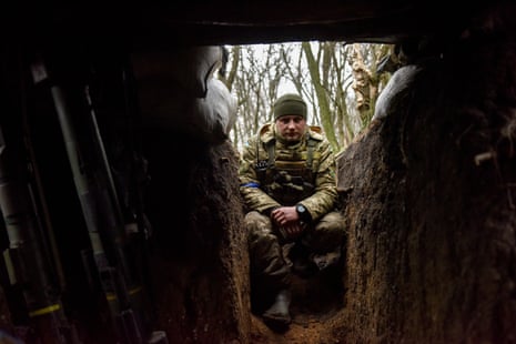 Seorang prajurit Ukraina duduk di parit di posisi garis depan di Donetsk