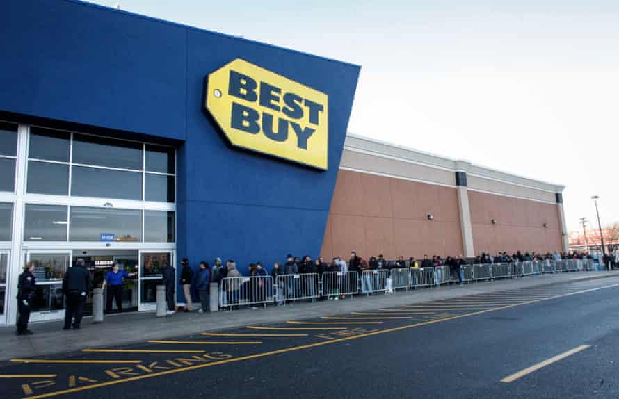 A Best Buy Employee opens the door to customers for Black Friday in Jersey City, New Jersey.