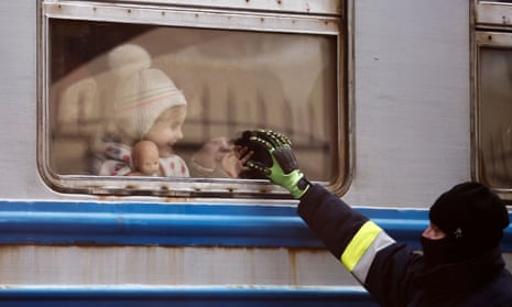 A Polish firefighter greets children who arrived in a Ukrainian train from Lviv.