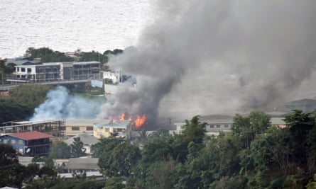 Smoke from fires rise from buildings in Honiara on Thursday.