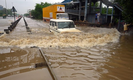 A vehicle being driven on a flooded highway in Gurgaon, on Delhi’s outskirts