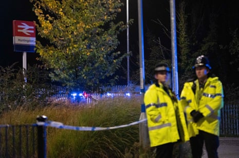 Police officers stand near a cordon outside Huntingdon Station on 2 November, 2025 in Huntingdon, England after a stabbing attack on a train.