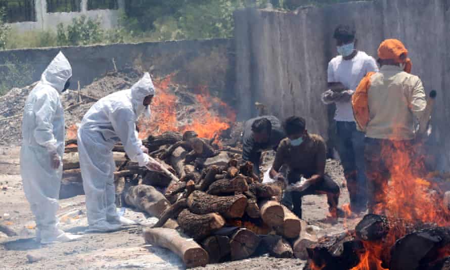 Relatives walk amid burning funeral pyres as they perform last rites for Covid-19 victims in Bhopal.