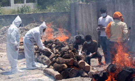 Relatives walk amid burning funeral pyres as they perform last rites for Covid-19 victims in Bhopal.