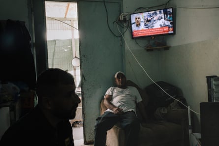 Men in front of a television watching the news from Gaza.
