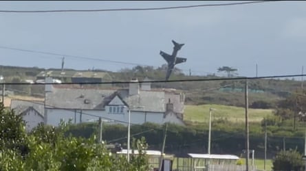 The jet, moments before it crashed, plummets towards a field behind a large farm.