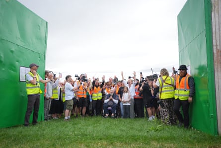lots of people behind some big green gates
