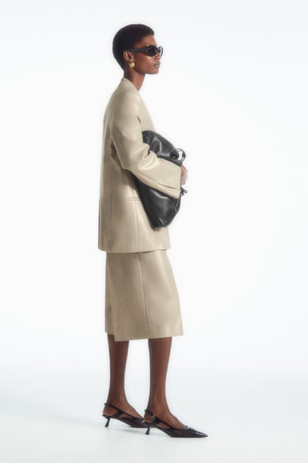 Model wearing cream with metallic thread Bermuda shorts matching blazer