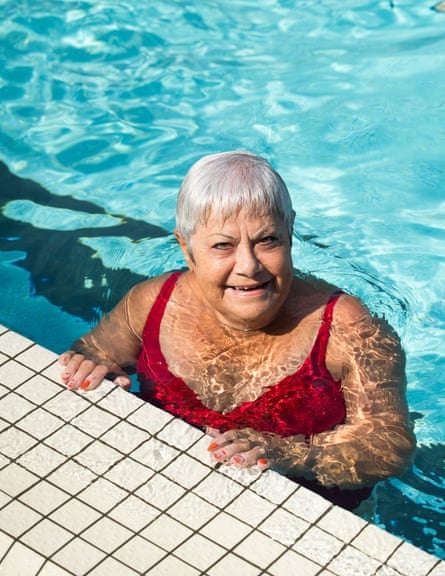Bernard in water holding on to poolside, smiling at camera