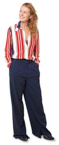 Zillah wears a red and white stripey shirt with wide-leg navy trousers, and has long blond hair.