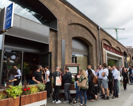 People queue outside Dishoom in King’s Cross, London.