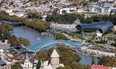 The Bridge of Peace, which some say looks like a discarded sanitary towel; to its right the conjoined concert hall and exhibition centre, and the presidential palace with its glass egg.