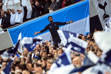 An image of Mauricio Pochettino seen on a banner among Spurs fans.