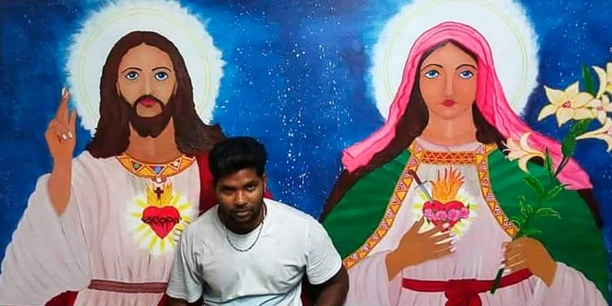 Thanush Selvarasa with the mural he painted for a small Catholic church in Papitalai parish on Manus Island.
