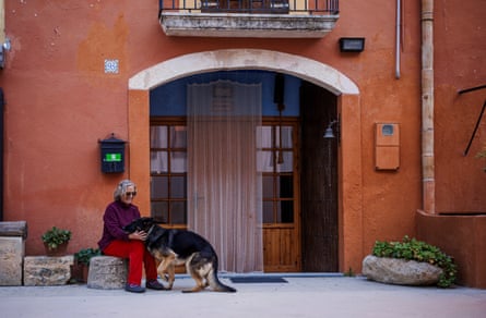 A woman pets a dog.