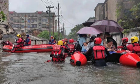 Rescue workers evacuate stranded residents on a flooded street following heavy rainfall in Beihai in China’s Guangxi region on 8 June