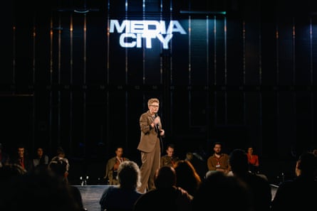 Bev Craig on stage speaking into a microphone.